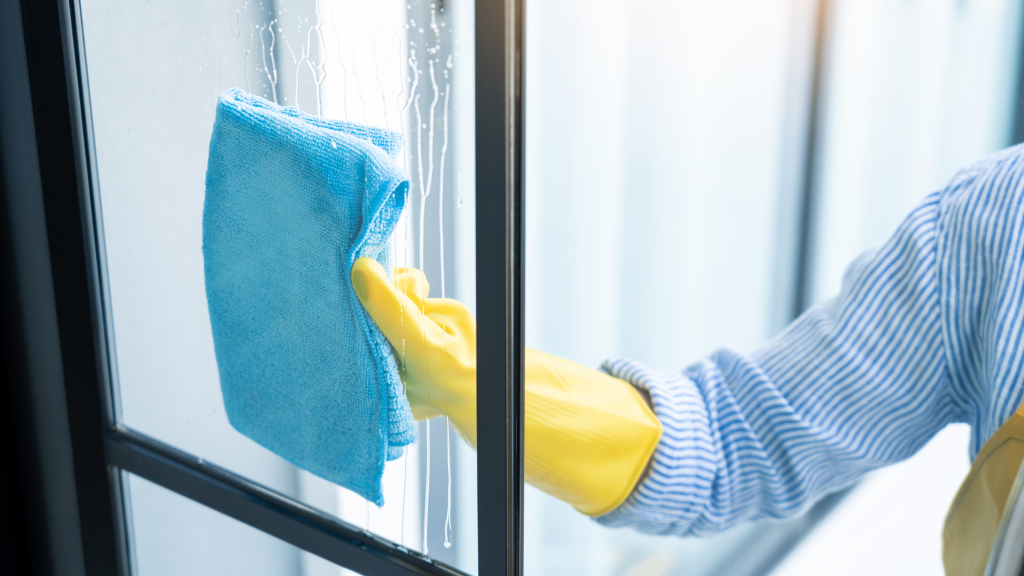 woman wiping clean window