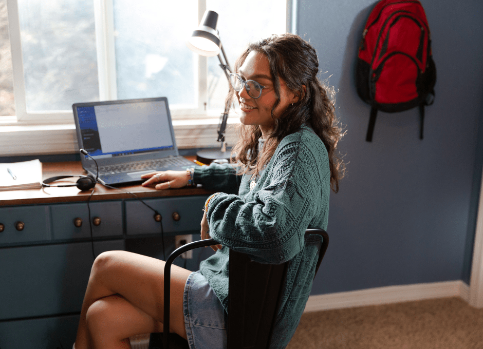 female college student sitting at desk in apartment