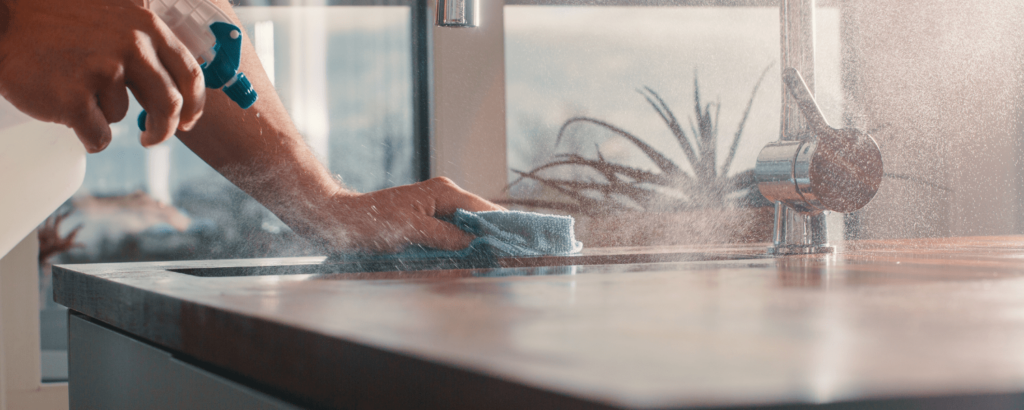 person using spray bottle with cloth