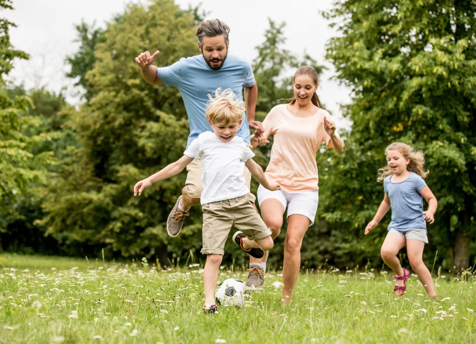 family playing soccer together outside