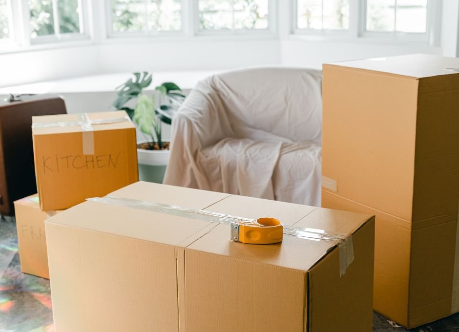 moving boxes in living room with covered chair