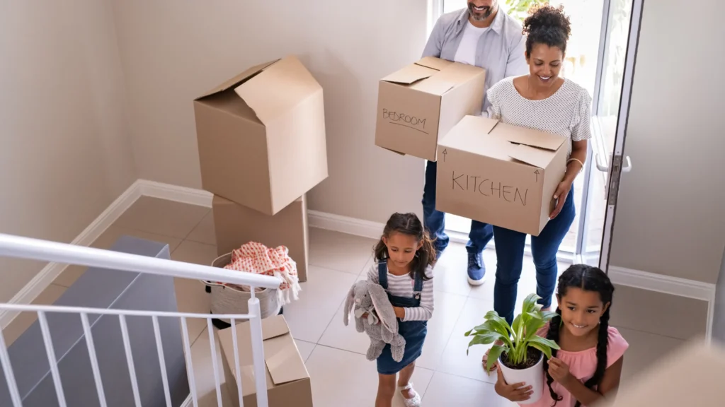 family walking into new home with moving boxes