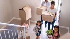 family walking into new home with moving boxes