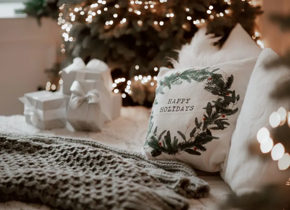 Bed with holiday pillows and Christmas tree