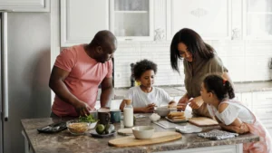 Happy family standing in kitchen making a meal